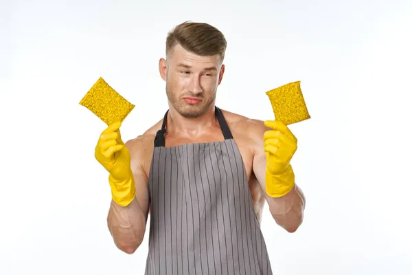 Un hombre en un delantal gris con guantes de goma lavado de limpieza — Foto de Stock