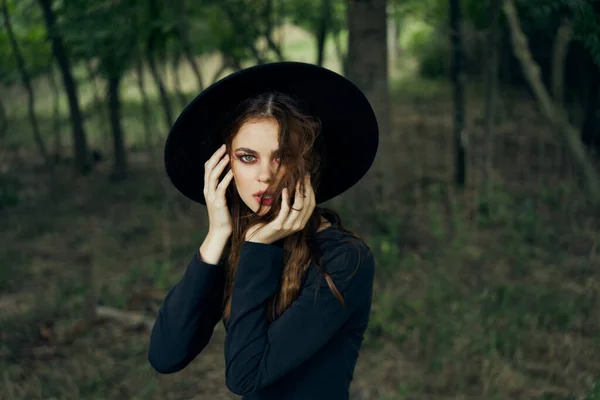 Siyah şapkalı kadın ormanda fantezi kuruyor. — Stok fotoğraf