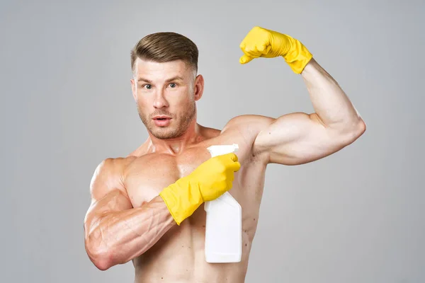 Hombre con músculos bombeados detergente posando limpieza — Foto de Stock