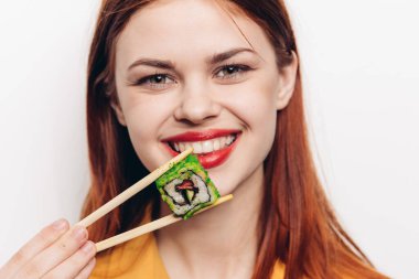 Neşeli kızıl saçlı kadın yemek çubukları suşi Japon mutfağı.