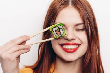 Neşeli kızıl saçlı kadın yemek çubukları suşi Japon mutfağı.