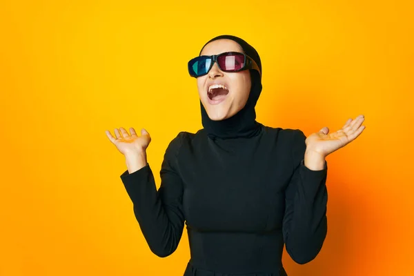 Мусульманин в черном хиджабе попкорн 3D очки кино желтый фон — стоковое фото