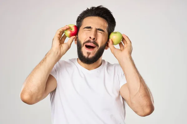 Hombre alegre con manzanas en las manos en una camiseta blanca frutas — Foto de Stock