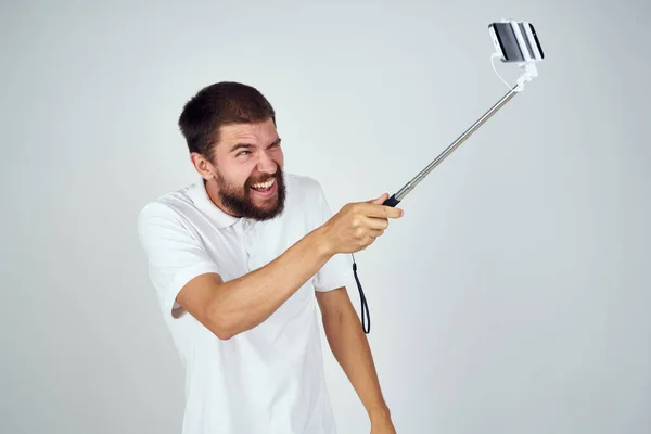 Чоловік у білій футболці selfie stick весела технологія фото — стокове фото