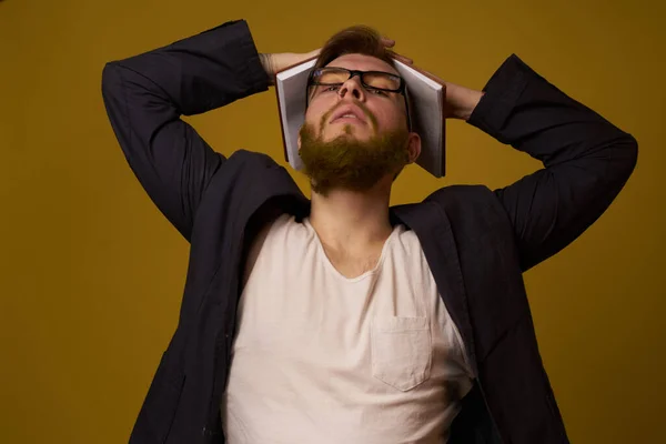 Man met baard in een zwart jasje met een boek in zijn handen onderwijs — Stockfoto