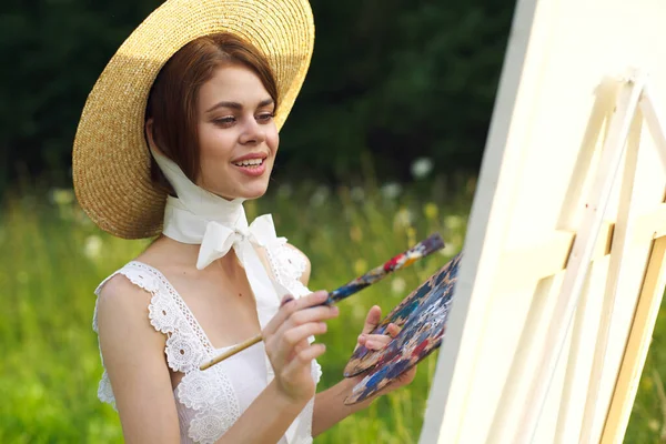 Vrouw in witte jurk kunstenaar schildert op het natuurlijke palet creatief — Stockfoto