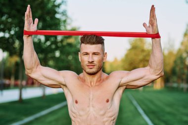 Parkın spor salonunda şişkin vücutlu atletik bir adam.