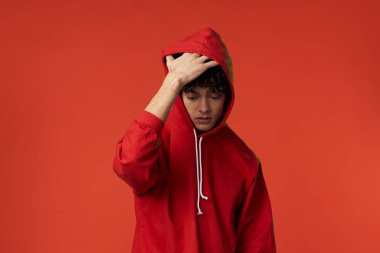 Kırmızı kazaklı bir adam kalp tatilinde poz veriyor.