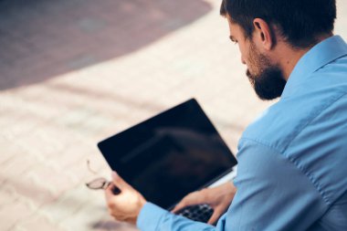 Sokakta çalışan tabletli adam.