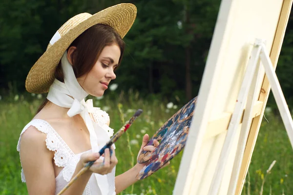 Frau mit einer Palette von Farben, die ein Bild im Freien aus nächster Nähe malen — Stockfoto