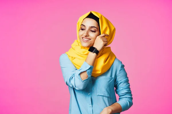 戴黄色头巾的妇女电子手表技术粉色背景 — 图库照片