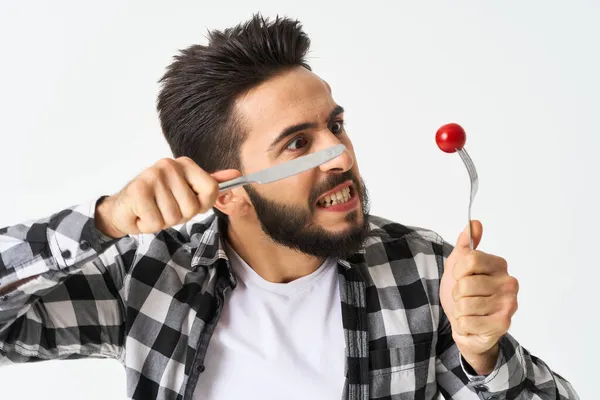 Barbudo homem com utensílios de cozinha cereja tomates lanche — Fotografia de Stock