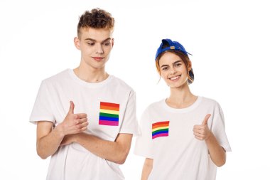 Beyaz tişörtlü genç çift lgbt travesti cinsel azınlıklar bayrağı taşıyor.