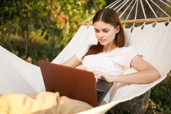 Kobieta z laptopem leży w hamaku freelance podróży — Zdjęcie stockowe