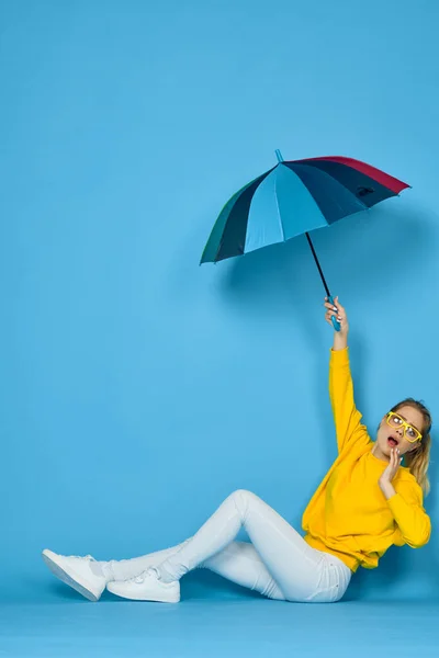 Frau mit buntem Regenschirm in gelbem Pullover posiert in Regenbogenfarben — Stockfoto