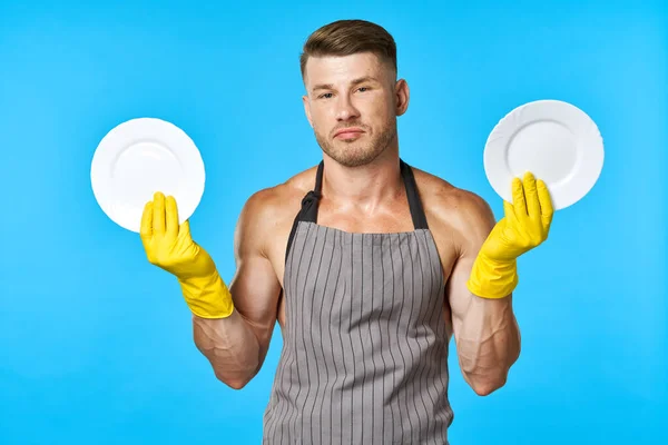 Vrolijke man in schorten afwassen huishoudelijke werk blauwe achtergrond — Stockfoto