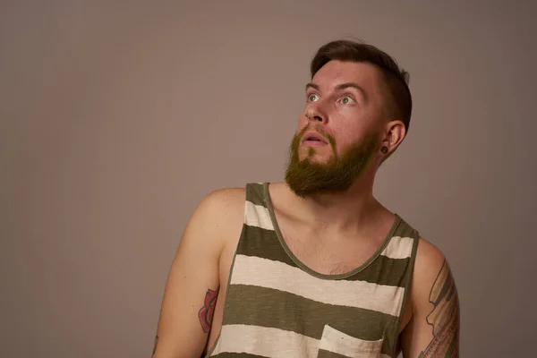 Национальный бородатый мужчина в полосатой майке татуировки хипстеров на руках — стоковое фото