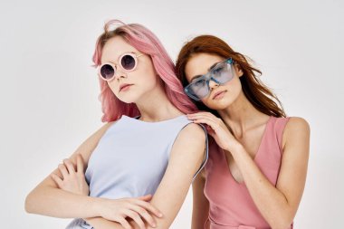 İki kadın yazın moda kıyafetler giyip aksesuar takıyor.