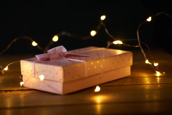 Pembe hediye kutusu çelenk dekorasyonu ahşap arka plan tatili — Stok fotoğraf
