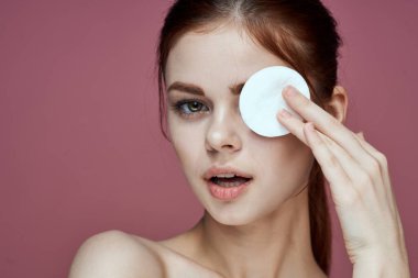 Çıplak omuzlu kadın pamuk pedleri saf ten cazibesi pembe arka plan