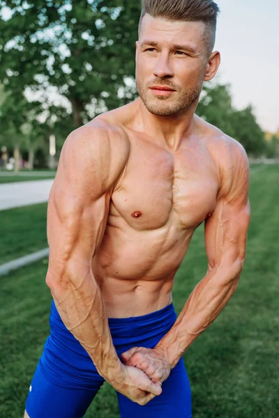 Deportista musculoso hombre con torso desnudo en un parque de entrenamiento —  Fotos de Stock