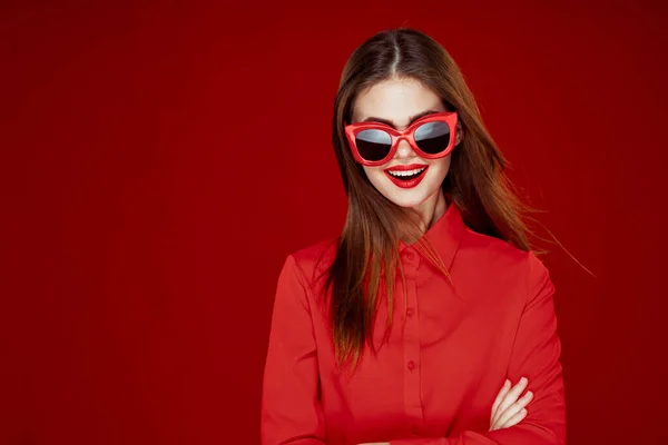 Krásná žena nosí sluneční brýle červená košile make-up izolované pozadí — Stock fotografie