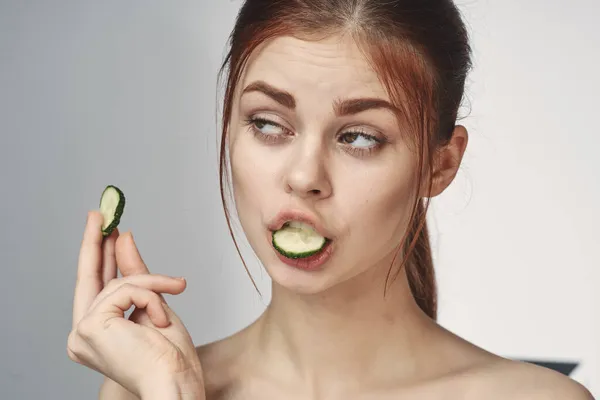 Vrolijke vrouw met komkommers in handen cosmetologie vitaminen gezondheid — Stockfoto