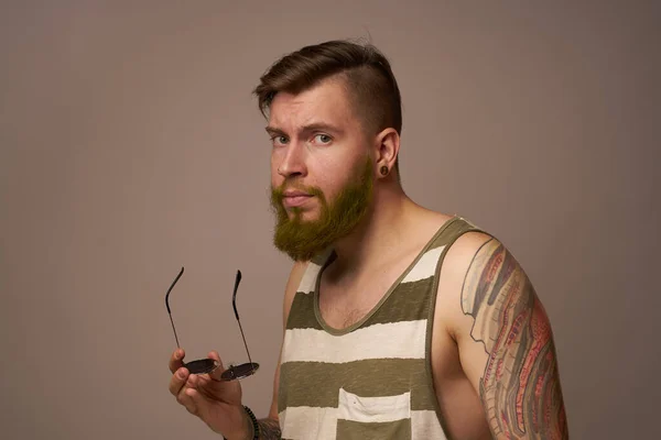 Homem barbudo em listrado t-shirt óculos tatuagem em seus braços moda — Fotografia de Stock