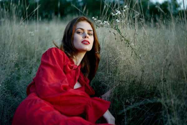 Kvinna i röd klänning ligger på gräset natur frihet vila — Stockfoto