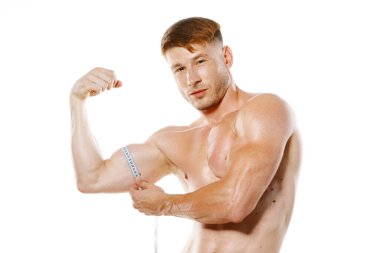 Atletik adam vücut geliştirici pozundaki kas uygunluğunu ölçer.