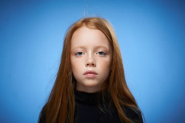 Rossa ragazza con lentiggini sul viso in posa primo piano sfondo blu — Foto Stock