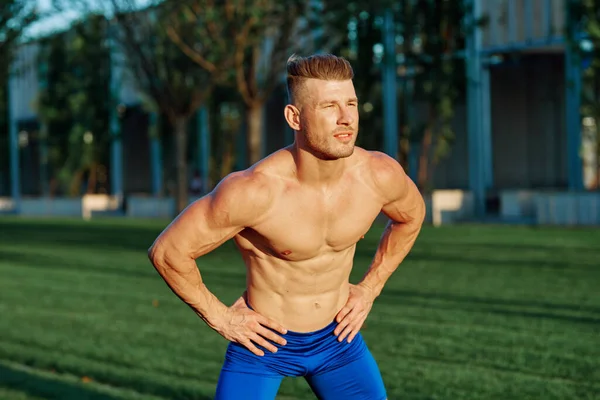 Homem com corpo muscular exercitando no parque de verão — Fotografia de Stock