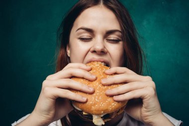 Hamburger yiyen bir kadın.