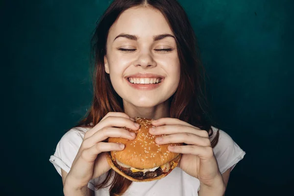 Femme gaie avec hamburger près du visage grignotage restauration rapide — Photo