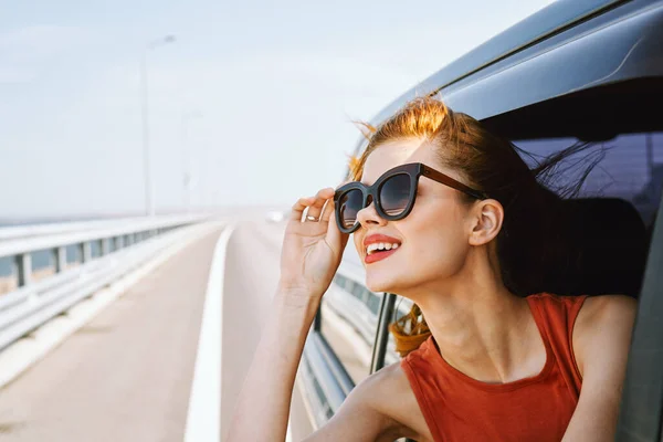 Hübsche Frau mit Sonnenbrille fährt im Reiseauto — Stockfoto