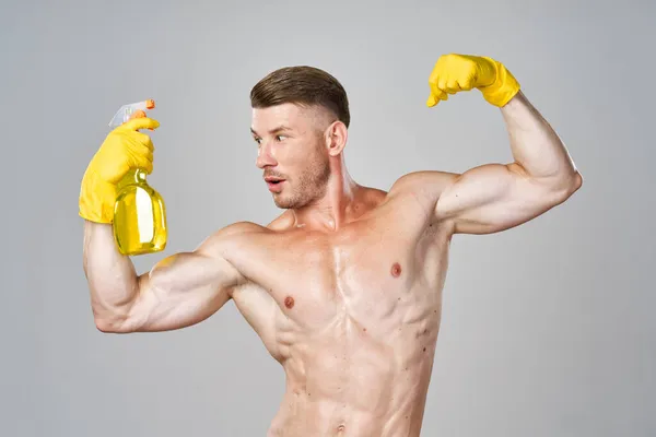 Muskulöser Mann mit Gummihandschuhen, der Hausaufgaben macht — Stockfoto