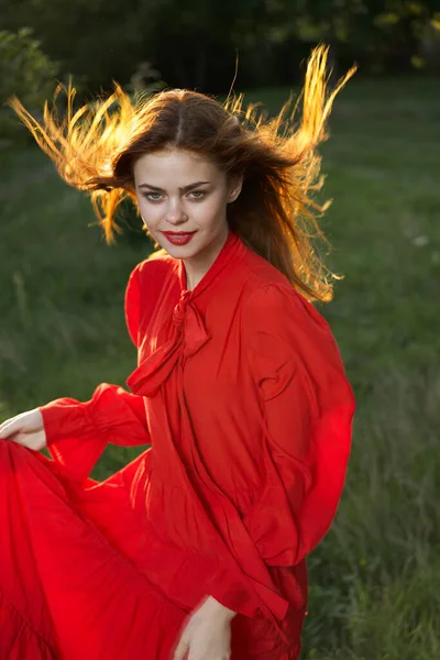 Kvinna i röd klänning poserar natur sol kul — Stockfoto