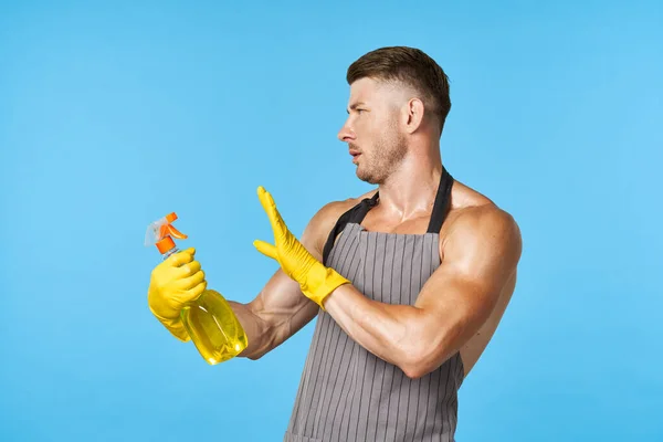 A man with a pumped-up body in aprons detergent cleaning — Stock Photo, Image