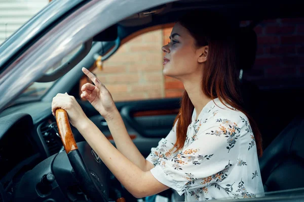 Mujer alegre conduciendo un coche mira por la ventana —  Fotos de Stock