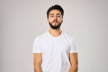 Beyaz tişörtlü, sağlıklı meyvelerin elinde elma olan neşeli bir adam.