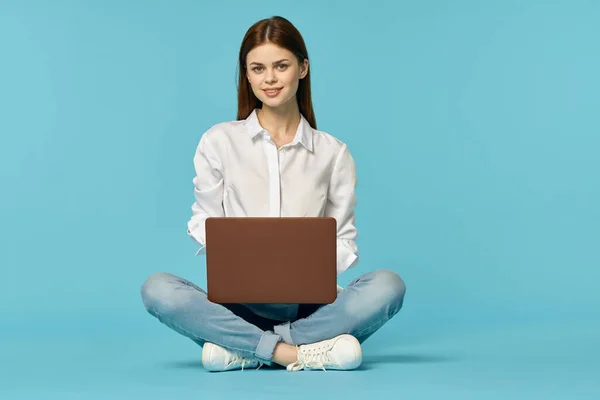Mujer con portátil aprendizaje internet educación en línea fondo azul — Foto de Stock