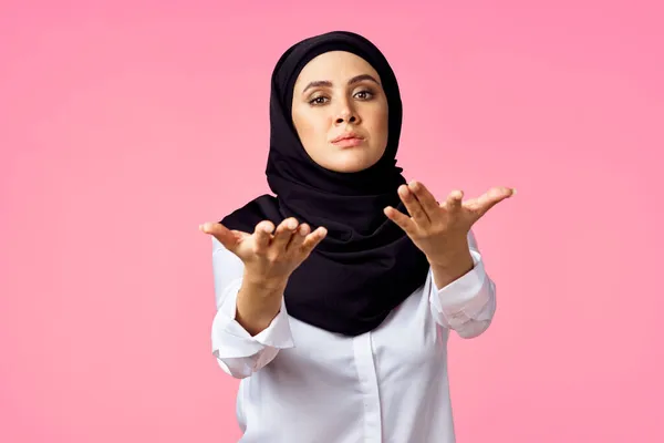 穆斯林妇女与计算器和金融货币粉红背景 — 图库照片