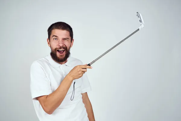 Man met baard in wit t-shirt selfie stick foto technologie — Stockfoto