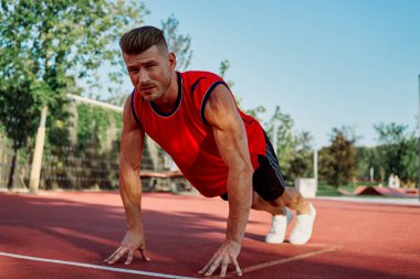 Spor sahası egzersizlerinde kaslı sporcular.