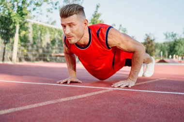 Spor sahası egzersizlerinde kaslı sporcular.