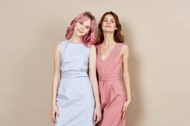 İki kadın yazın moda kıyafetler giyip aksesuar takıyor.