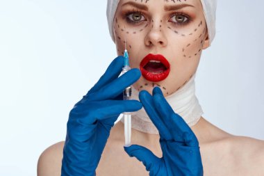 Mavi eldivenli bir kadının portresi. Ellerinde şırınga var. Yüz çevresi soyutlanmış arka plan kaldırıyor.