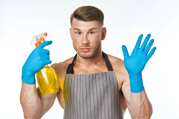 Man in schort schoonmaakmiddel schoonmaak dienst lichte achtergrond — Stockfoto