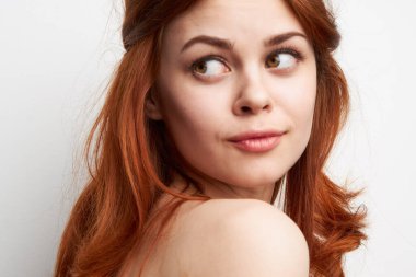 Çıplak omuzlu, neşeli bir kadın. Saç stili, göz alıcı.