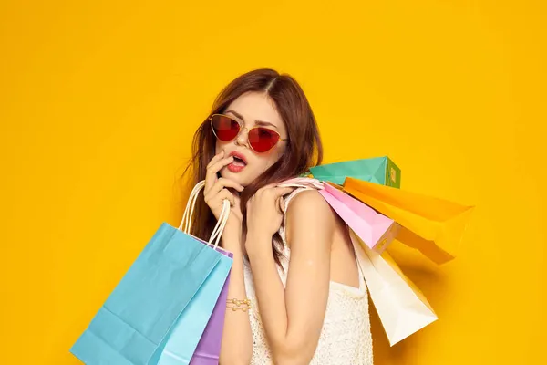Leende kvinna bär solglasögon poserar shopping mode studio modell — Stockfoto